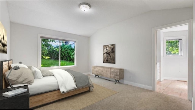 bedroom featuring vaulted ceiling and light carpet