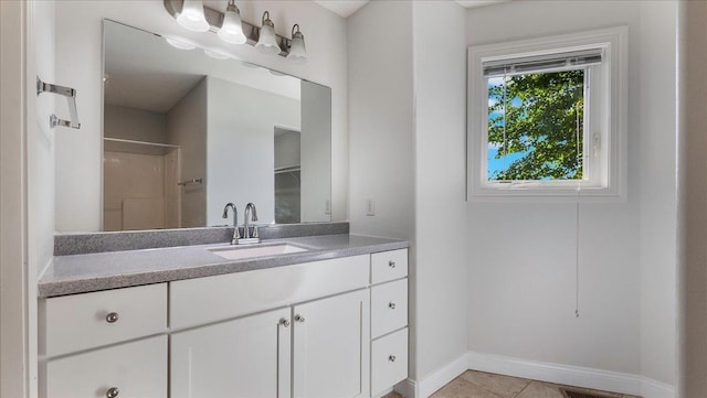 bathroom featuring vanity, tile patterned flooring, and a shower