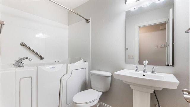 bathroom featuring sink, a bathtub, and toilet