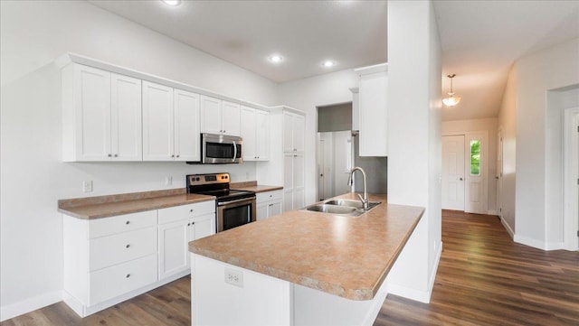 kitchen featuring dark wood-type flooring, sink, white cabinetry, kitchen peninsula, and stainless steel appliances