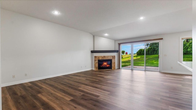 unfurnished living room featuring a tile fireplace and dark hardwood / wood-style floors