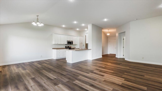 kitchen with sink, dark wood-type flooring, appliances with stainless steel finishes, white cabinets, and kitchen peninsula