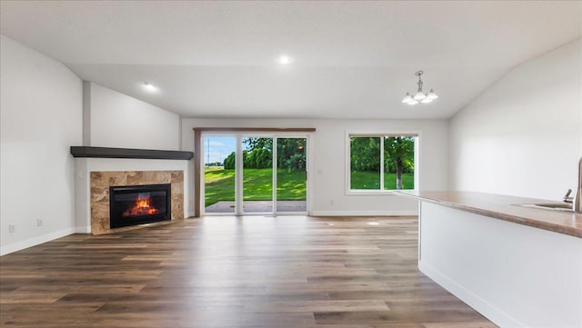 unfurnished living room with hardwood / wood-style flooring, vaulted ceiling, and a wealth of natural light