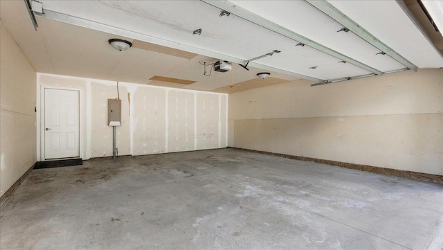 garage with a garage door opener and electric panel