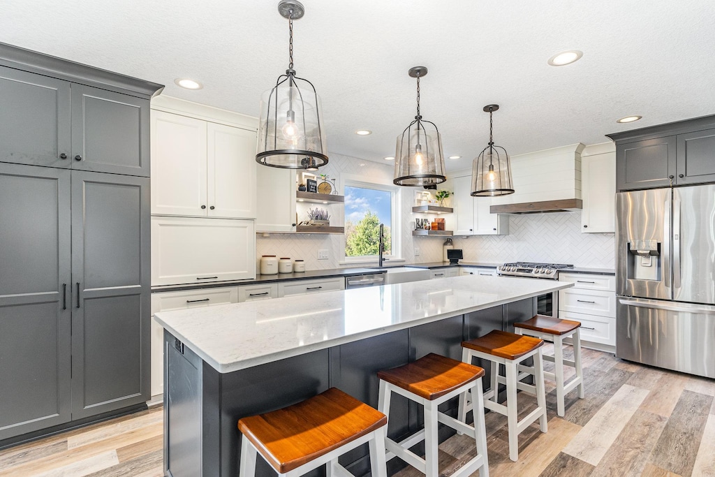 kitchen with custom range hood, a center island, stainless steel appliances, and gray cabinetry