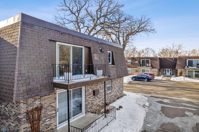 snow covered property featuring a balcony