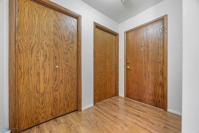 foyer featuring a textured ceiling and light hardwood / wood-style flooring