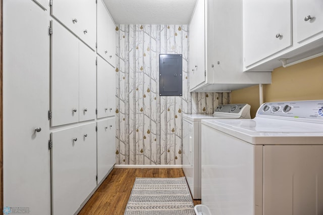 laundry area featuring cabinets, a textured ceiling, washing machine and clothes dryer, hardwood / wood-style floors, and electric panel