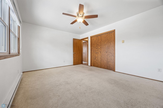 unfurnished bedroom with light colored carpet, ceiling fan, and a baseboard heating unit