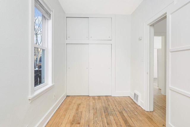 unfurnished bedroom featuring light hardwood / wood-style floors and a closet