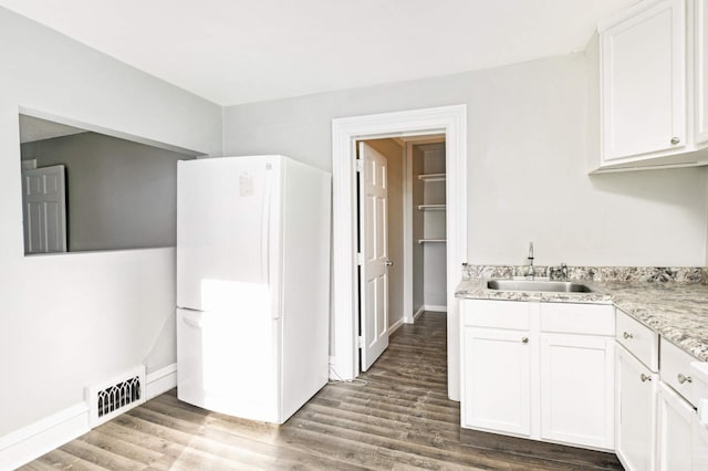 kitchen featuring white cabinets, white refrigerator, hardwood / wood-style flooring, and sink