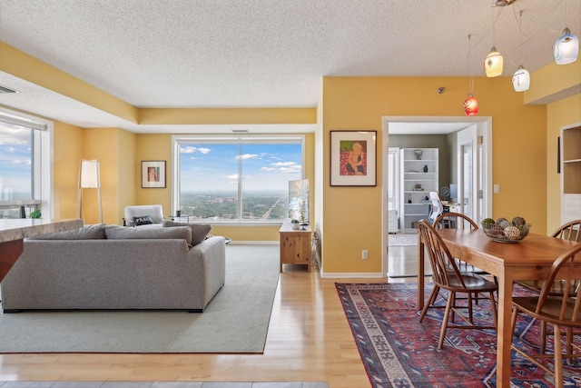 living room featuring built in features, hardwood / wood-style floors, and a textured ceiling