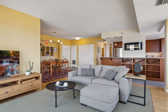 living room featuring a textured ceiling and light hardwood / wood-style flooring