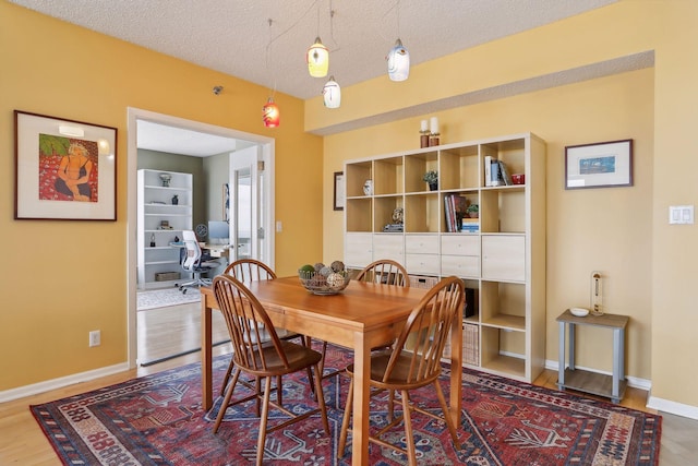 dining area featuring hardwood / wood-style floors and a textured ceiling