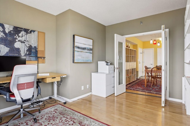 office area with a chandelier, a textured ceiling, and light hardwood / wood-style flooring