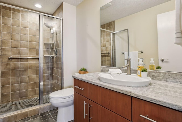 bathroom featuring an enclosed shower, a textured ceiling, vanity, tile patterned flooring, and toilet