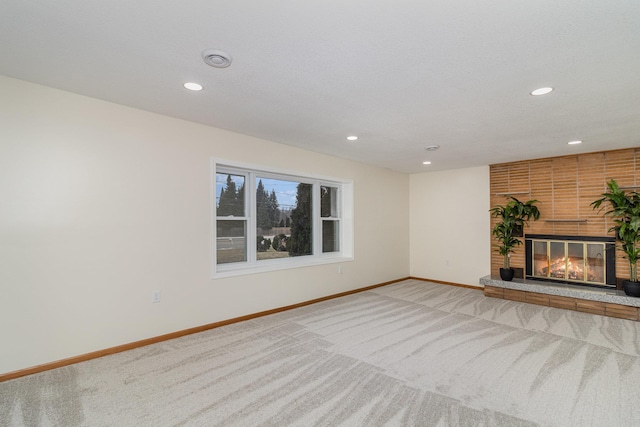 unfurnished living room featuring carpet and a brick fireplace