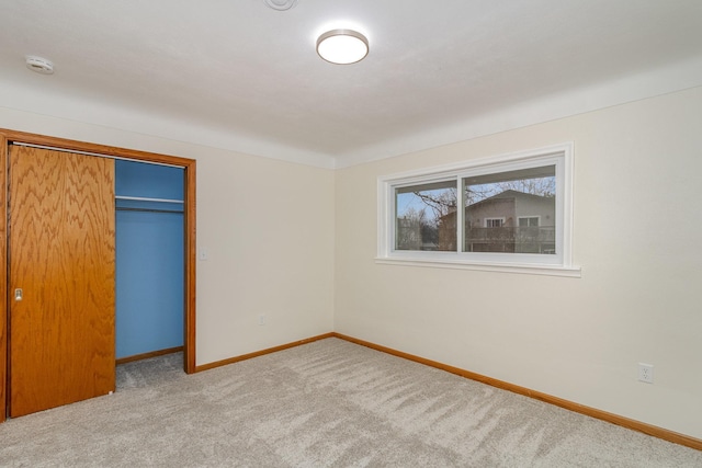 unfurnished bedroom featuring light colored carpet and a closet