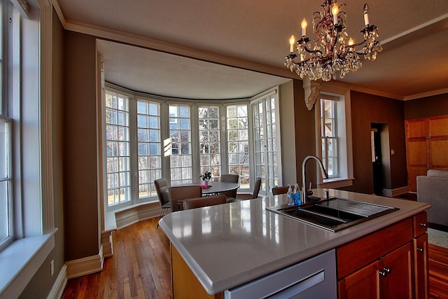 kitchen with dishwasher, a center island with sink, sink, ornamental molding, and a notable chandelier