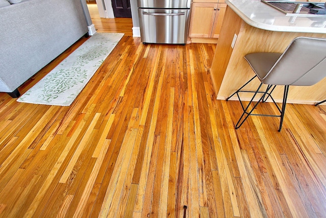 interior space featuring wood-type flooring and fridge