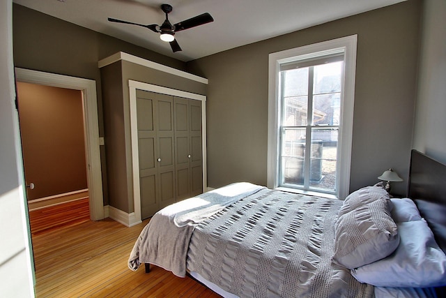 bedroom with ceiling fan, a closet, and light wood-type flooring