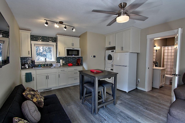 kitchen with white cabinetry, sink, dark hardwood / wood-style floors, backsplash, and white fridge