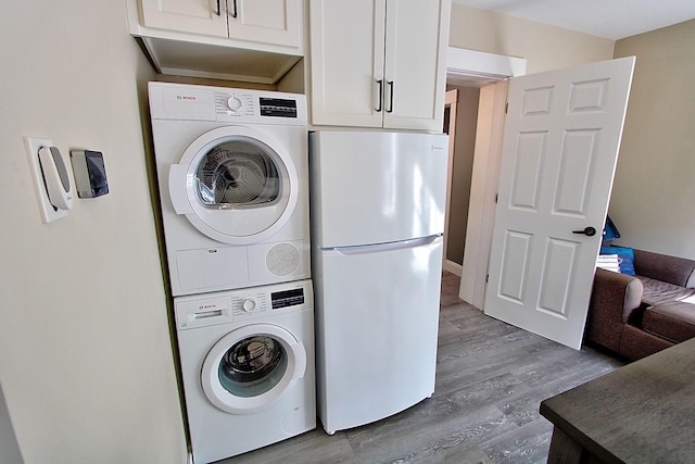 laundry room with wood-type flooring and stacked washing maching and dryer