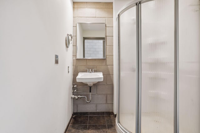 bathroom with a shower with shower door and sink