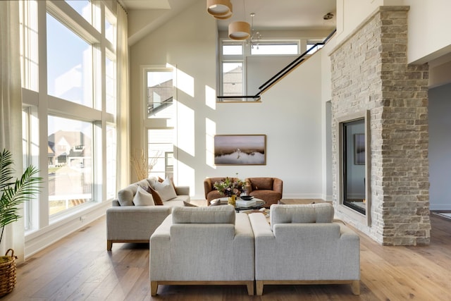 living room with light wood-type flooring and a high ceiling