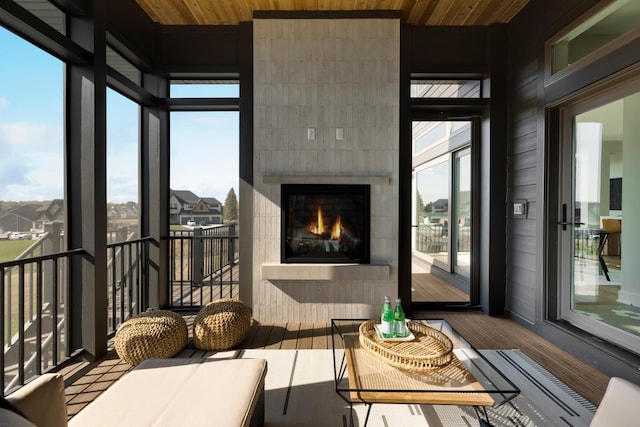 sunroom featuring a tile fireplace and plenty of natural light