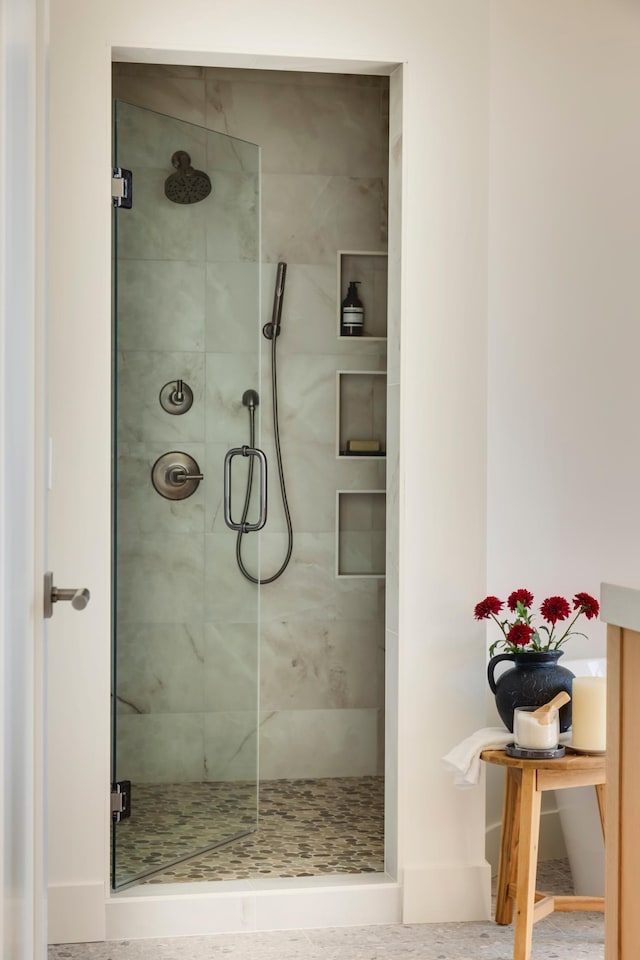 bathroom featuring a shower with door