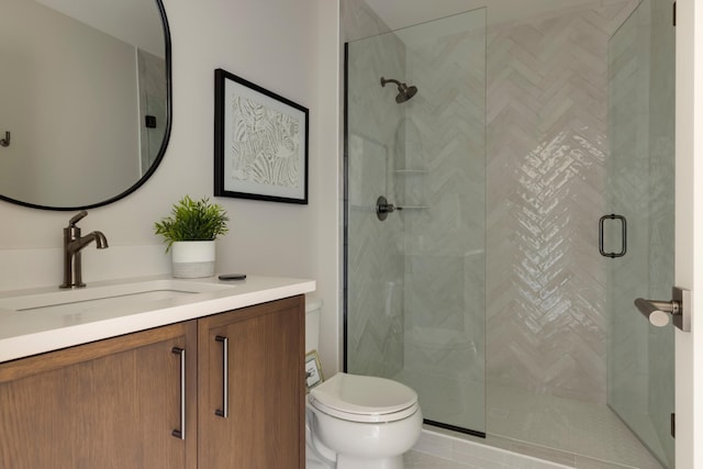 bathroom featuring vanity, an enclosed shower, and toilet