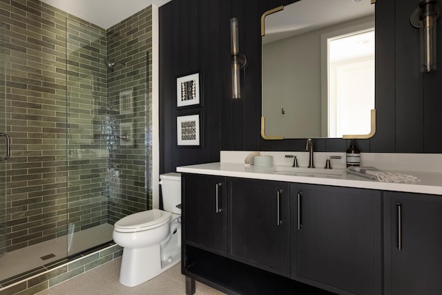 bathroom featuring tile patterned floors, vanity, toilet, and a shower with door