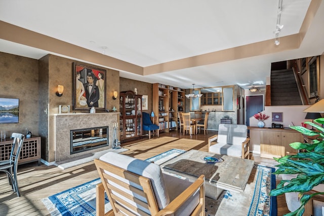 living room featuring ceiling fan, a fireplace, and track lighting