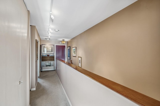 corridor featuring light carpet and track lighting