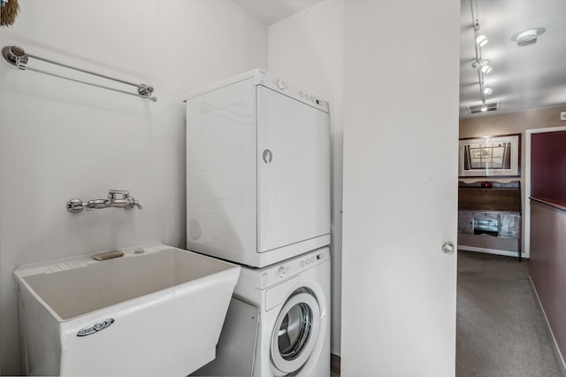 clothes washing area with stacked washer / dryer, sink, and carpet