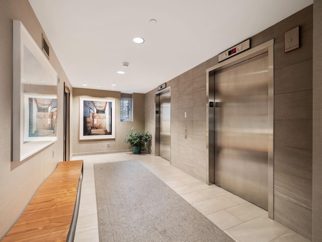 corridor with elevator and light tile patterned floors