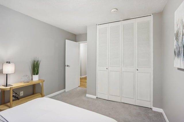 bedroom featuring light carpet and a closet