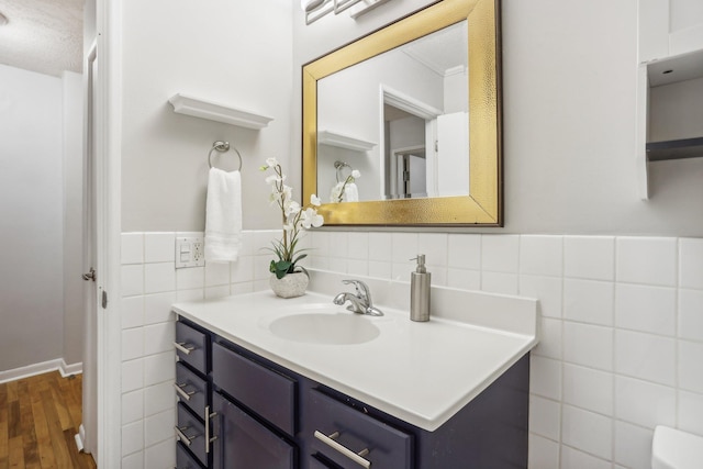 bathroom with wood-type flooring, vanity, and tile walls