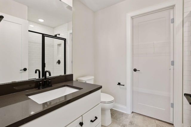 bathroom with vanity, an enclosed shower, and toilet