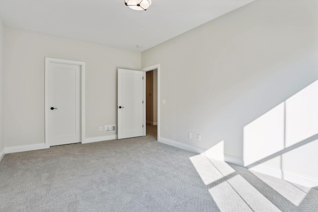 spare room featuring light colored carpet