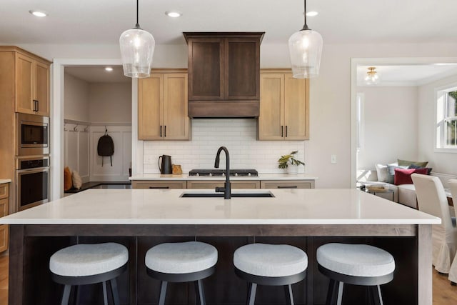 kitchen featuring a spacious island, appliances with stainless steel finishes, decorative light fixtures, and custom exhaust hood