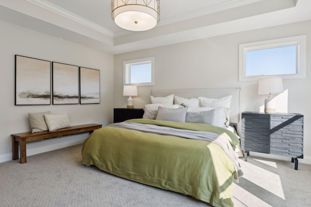 bedroom featuring light colored carpet, ornamental molding, and a tray ceiling