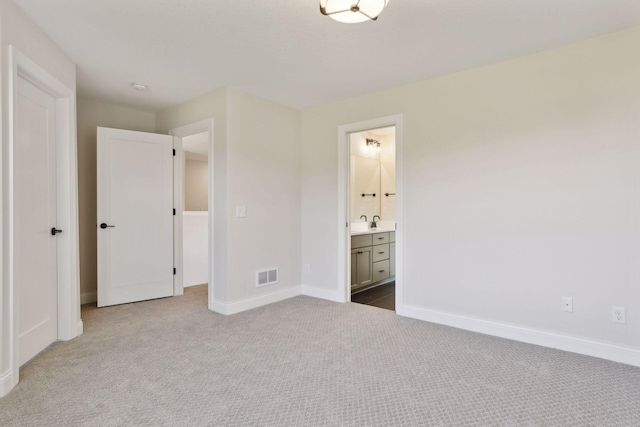 unfurnished bedroom featuring connected bathroom and carpet flooring