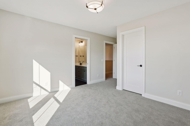 unfurnished bedroom featuring light colored carpet and ensuite bathroom