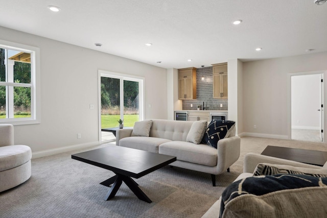 living room with beverage cooler, wet bar, and light carpet