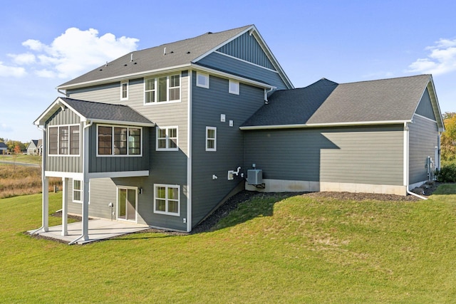 back of property with a patio, a lawn, and central air condition unit