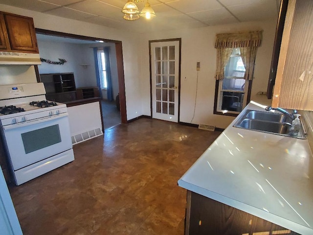 kitchen featuring a notable chandelier, white gas range, and sink