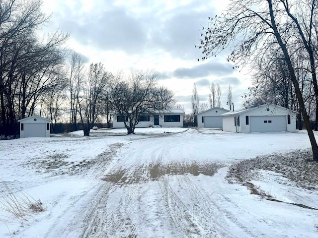 yard covered in snow with an outbuilding and a garage