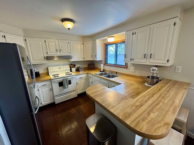 kitchen featuring kitchen peninsula, black fridge, white range with electric cooktop, and white cabinets